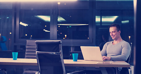 Image showing man working on laptop in dark office