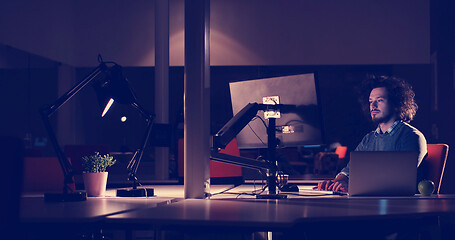 Image showing man working on computer in dark office