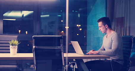 Image showing man working on laptop in dark office