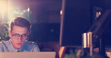 Image showing man working on computer in dark office