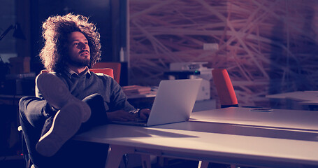 Image showing businessman sitting with legs on desk at office