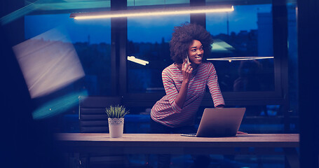 Image showing black businesswoman using a laptop in night startup office