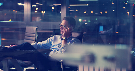 Image showing businessman sitting with legs on desk at office