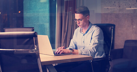 Image showing man working on laptop in dark office