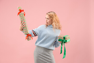 Image showing Woman with big beautiful smile holding colorful gift boxes.