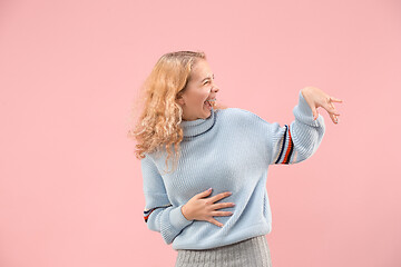 Image showing The happy business woman standing and smiling against pink background.