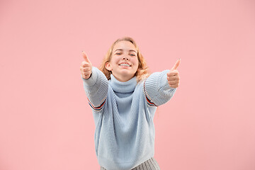 Image showing The happy business woman standing and smiling against pink background.