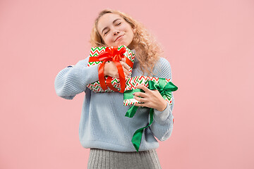 Image showing Woman with big beautiful smile holding colorful gift boxes.