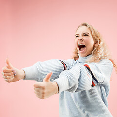 Image showing The happy business woman standing and smiling against pink background.