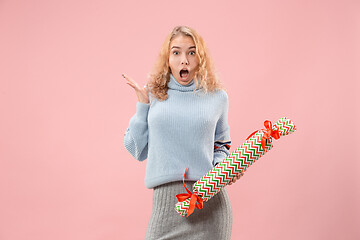 Image showing Woman with big beautiful smile holding colorful gift box.