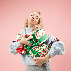 Image showing Woman with big beautiful smile holding colorful gift boxes.