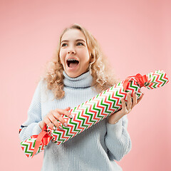 Image showing Woman with big beautiful smile holding colorful gift box.