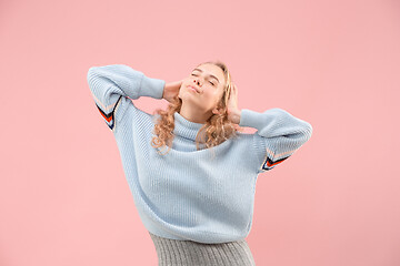 Image showing The happy business woman standing and smiling against pink background.