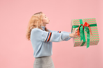 Image showing Woman with big beautiful smile holding colorful gift box.