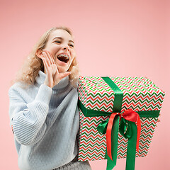 Image showing Woman with big beautiful smile holding colorful gift box.