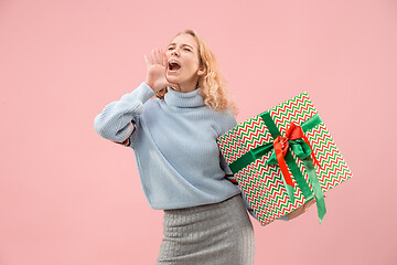 Image showing Woman with big beautiful smile holding colorful gift box.