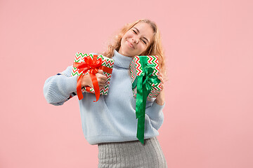 Image showing Woman with big beautiful smile holding colorful gift boxes.