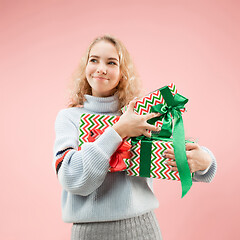 Image showing Woman with big beautiful smile holding colorful gift boxes.