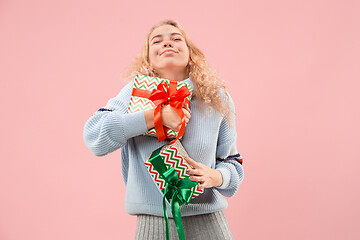 Image showing Woman with big beautiful smile holding colorful gift boxes.