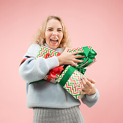 Image showing Woman with big beautiful smile holding colorful gift boxes.