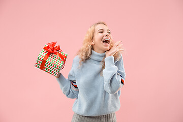 Image showing Woman with big beautiful smile holding colorful gift box.