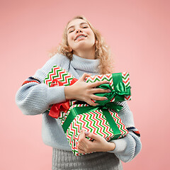 Image showing Woman with big beautiful smile holding colorful gift boxes.