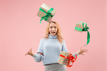 Image showing Woman with big beautiful smile holding colorful gift boxes.