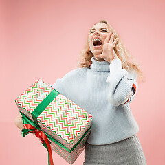 Image showing Woman with big beautiful smile holding colorful gift box.