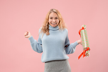 Image showing Woman with big beautiful smile holding colorful gift box.