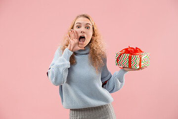 Image showing Woman with big beautiful smile holding colorful gift box.