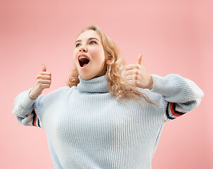 Image showing The happy business woman standing and smiling against pink background.