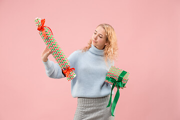 Image showing Woman with big beautiful smile holding colorful gift boxes.