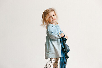 Image showing Full length portrait of cute little kid in stylish jeans clothes looking at camera and smiling