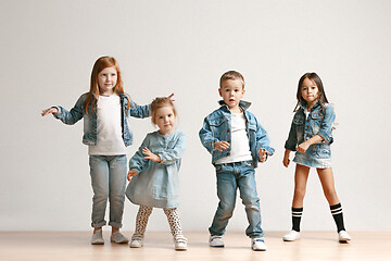 Image showing The portrait of cute little boy and girls in stylish jeans clothes looking at camera at studio