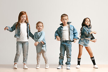 Image showing The portrait of cute little boy and girls in stylish jeans clothes looking at camera at studio