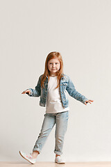 Image showing Full length portrait of cute little kid in stylish jeans clothes looking at camera and smiling