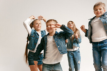 Image showing The portrait of cute little boy and girls in stylish jeans clothes looking at camera at studio