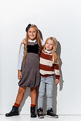 Image showing The portrait of cute little girls in stylish jeans clothes looking at camera at studio