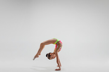 Image showing The teenager girl doing gymnastics exercises isolated on white background