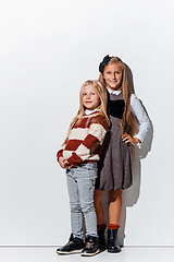 Image showing The portrait of cute little girls in stylish jeans clothes looking at camera at studio