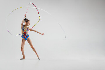 Image showing The portrait of beautiful young brunette woman gymnast training calilisthenics exercise with ribbon