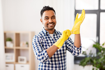 Image showing indian man putting protective rubber gloves on