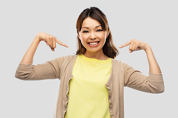 Image showing happy asian woman over grey background