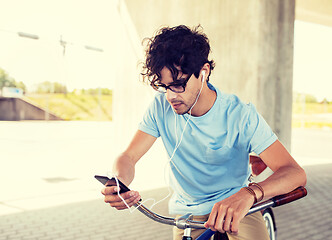 Image showing man with smartphone and earphones on bicycle