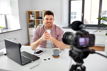 Image showing male blogger with camera videoblogging at home