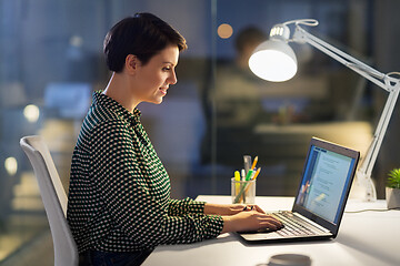 Image showing businesswoman working on laptop at night office