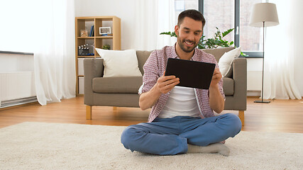 Image showing smiling man using tablet computer at home