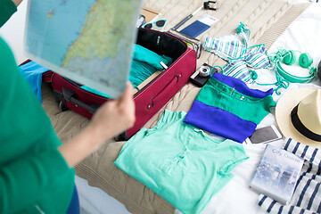 Image showing close up of woman with map packing travel bag