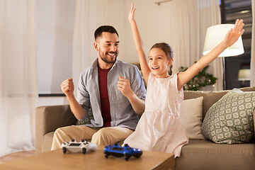 Image showing father and daughter playing video game at home
