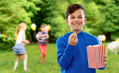 Image showing smiling boy eating popcorn at birthday party